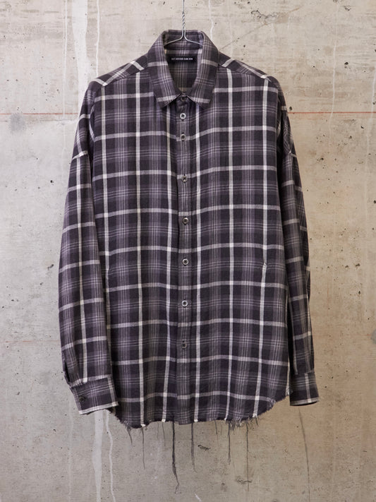 Plaid shirt on a hanger against a concrete wall