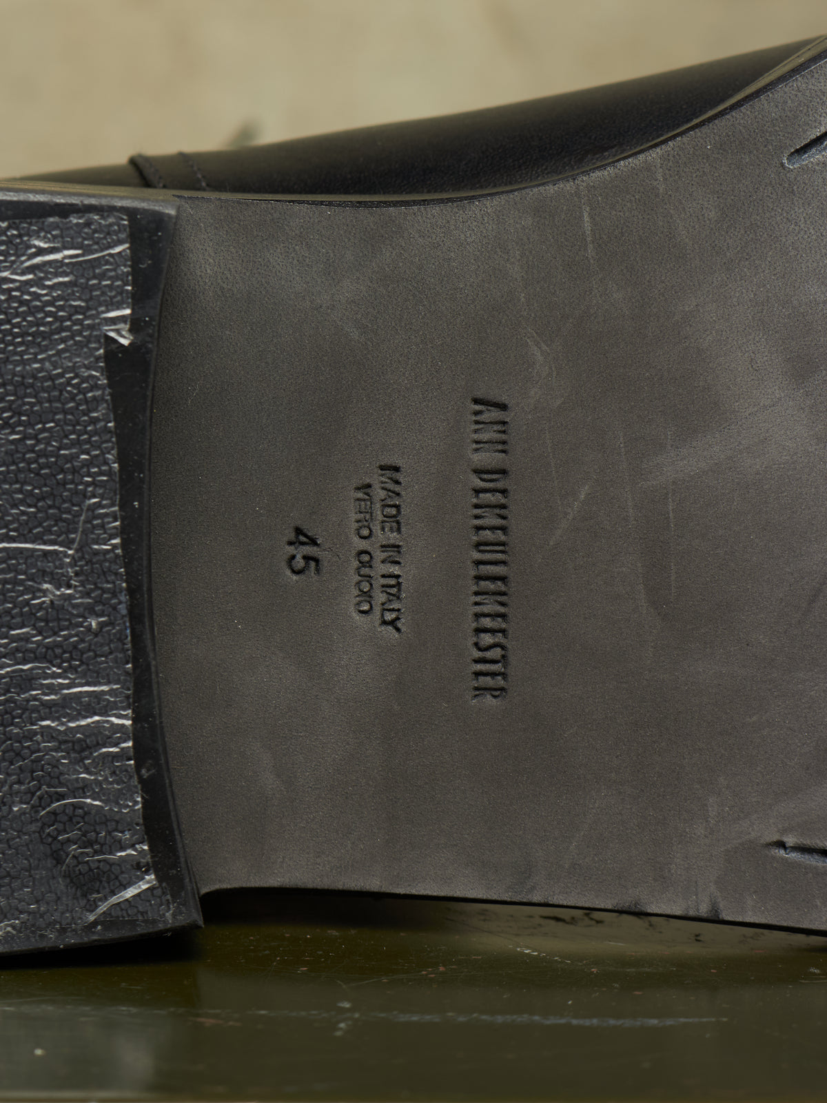 Close-up of the underside of a black leather shoe showing the insole with embossed text reading 'ANNI DETTORLEESKE' and size '45'.