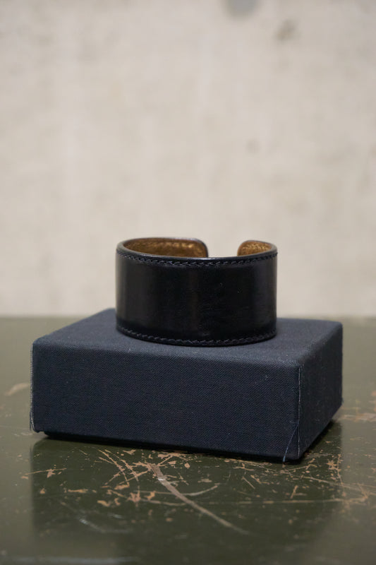 Black leather cuff on a blue box with a gray background