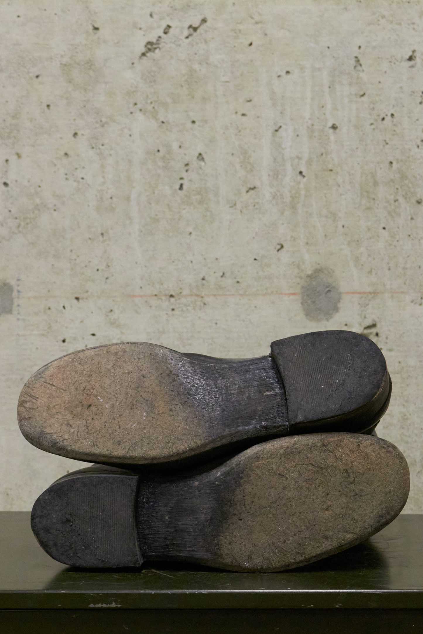 Pair of worn shoes on a concrete surface