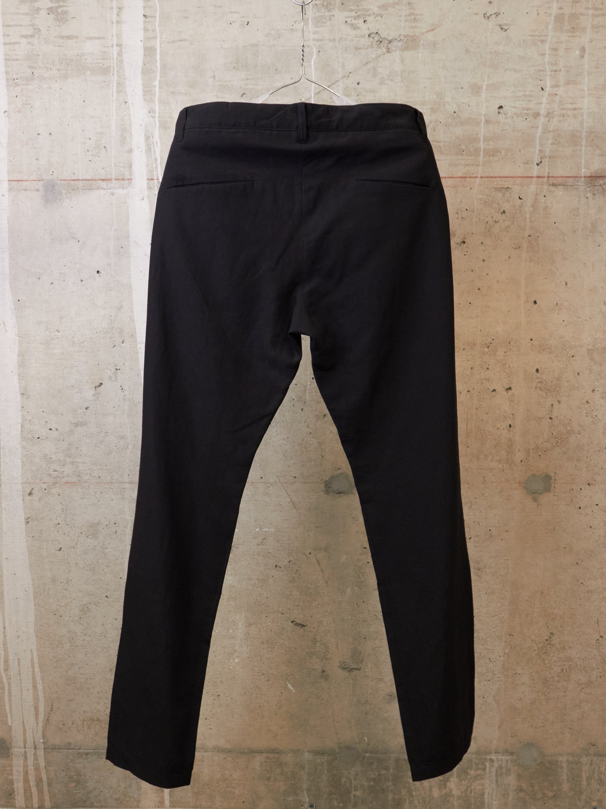 Black pants on a textured beige background