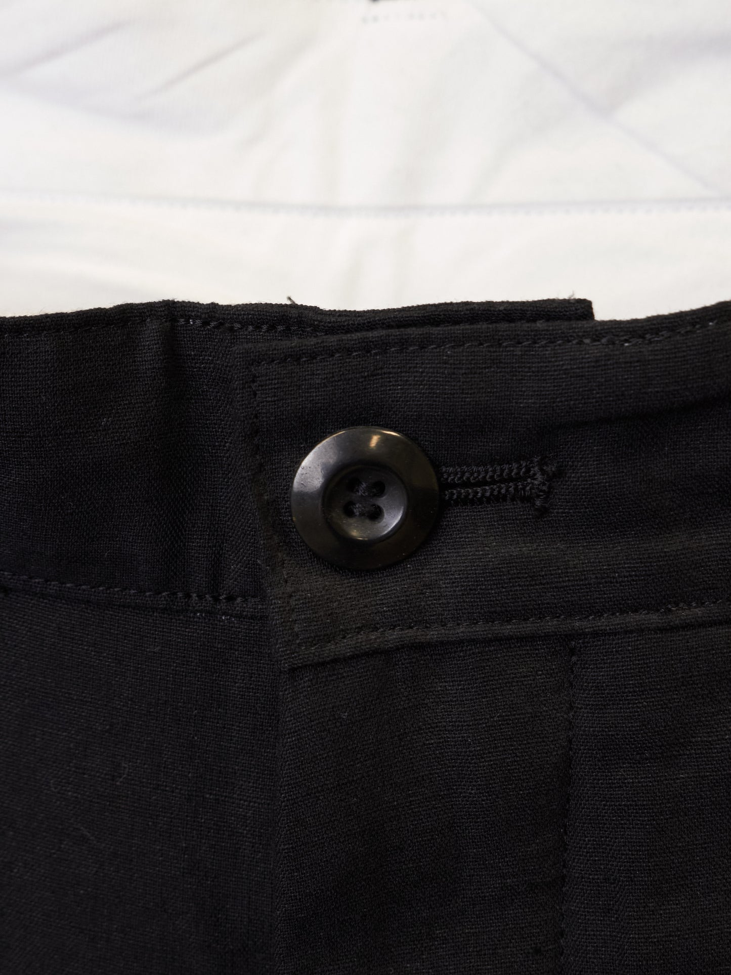 Close-up of a black button on a black fabric background