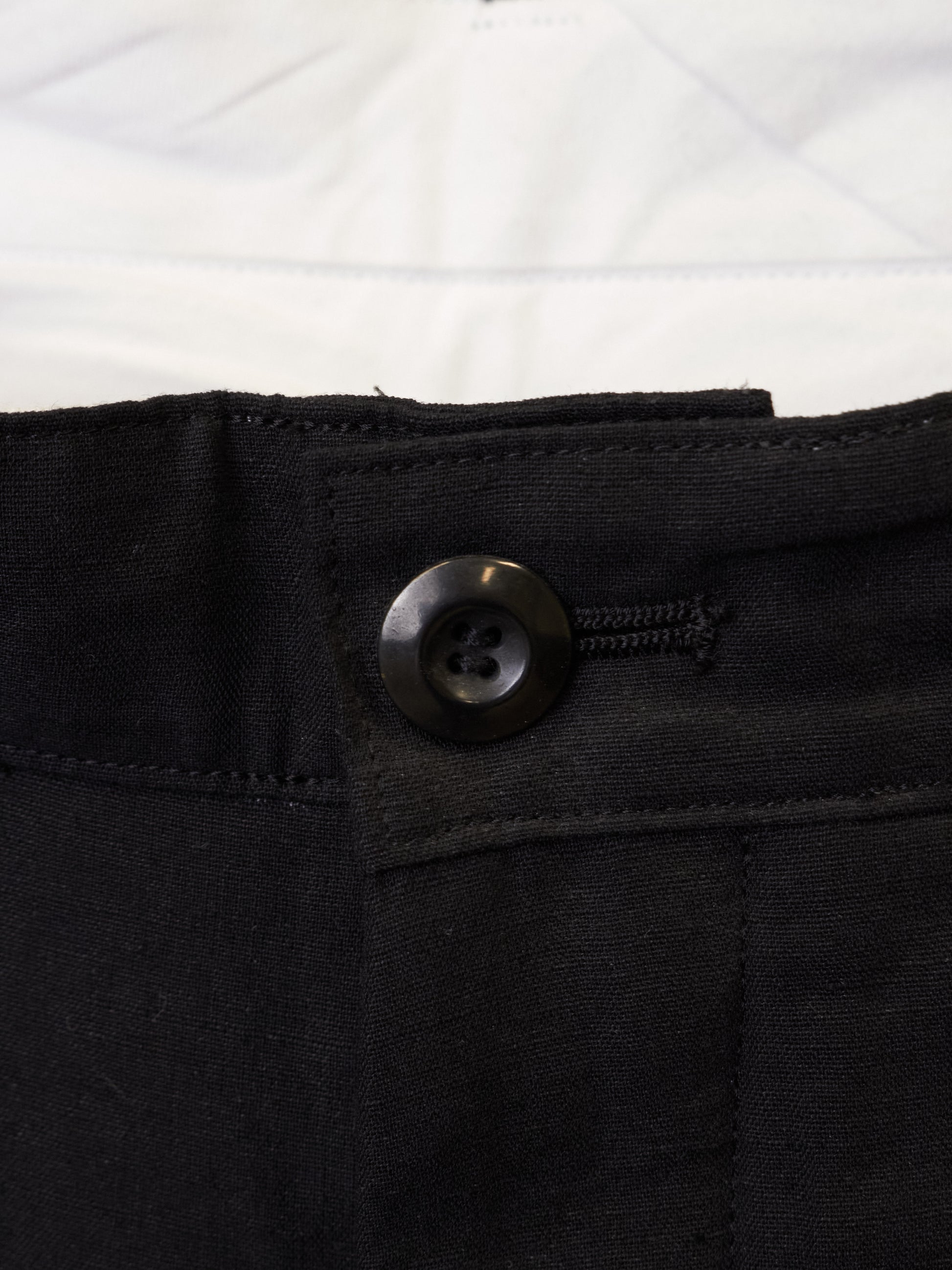 Close-up of a black button on a black fabric background