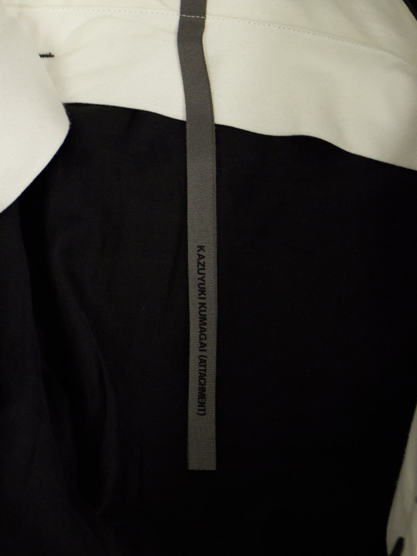 Close-up of a black and white garment with a visible brand label.