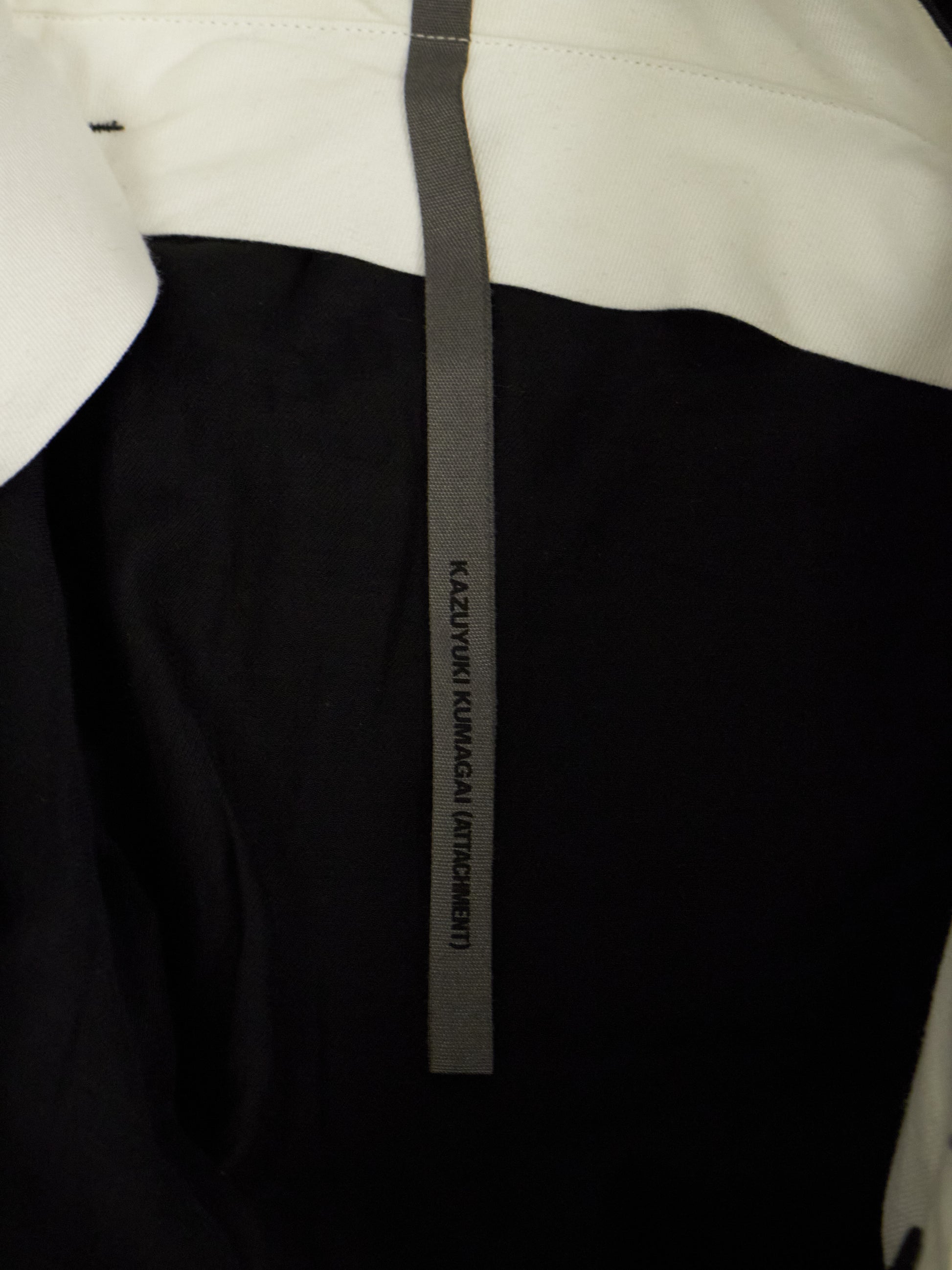 Close-up of a black and white garment with a visible brand label.