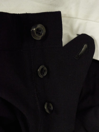 Close-up of a black coat with buttons on a white background