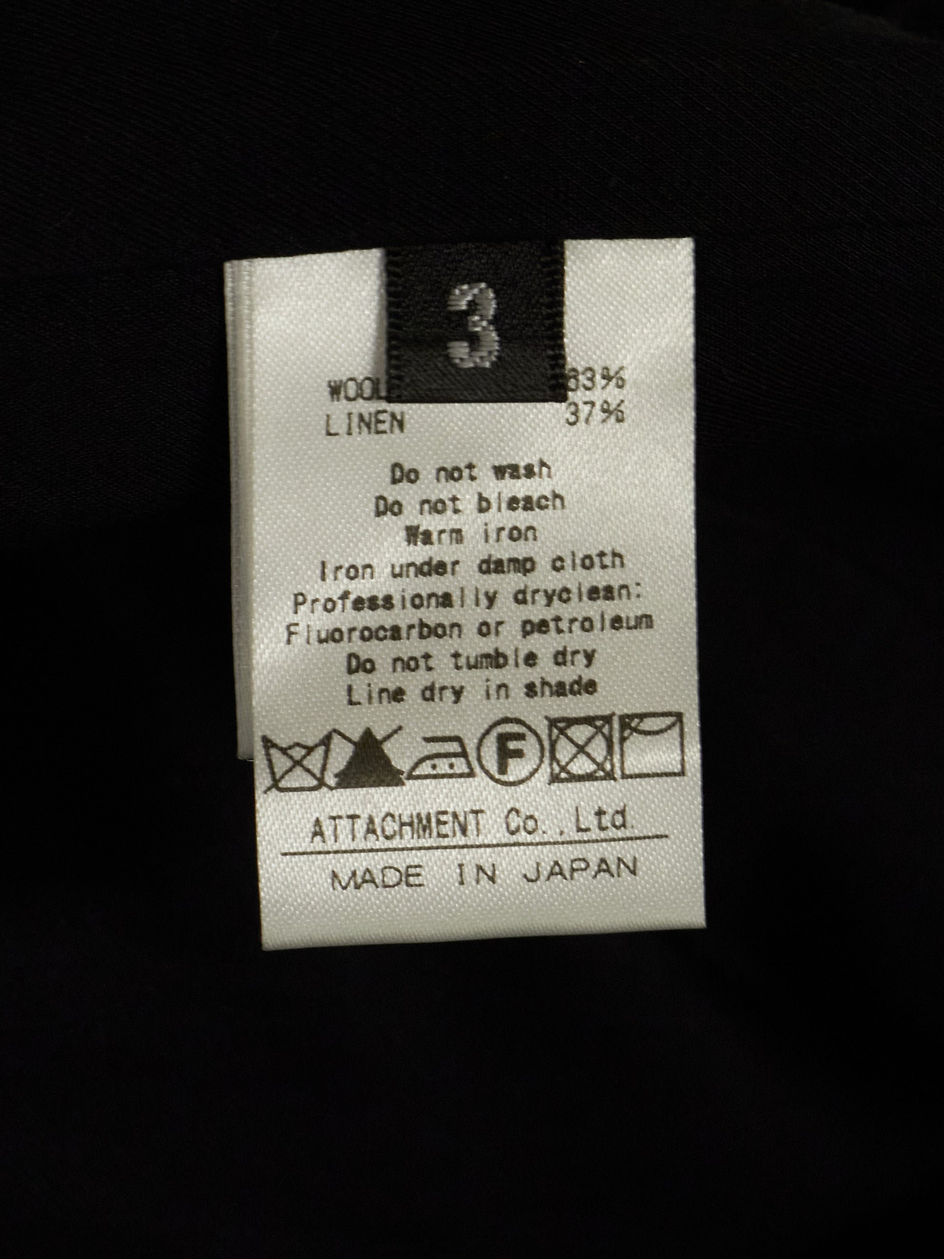 Clothing label with care instructions on a black background