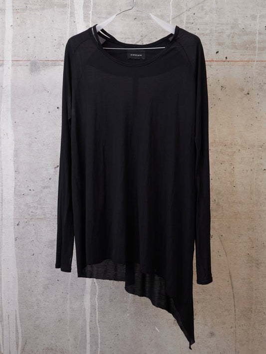 Black long-sleeve top on a hanger against a textured wall.