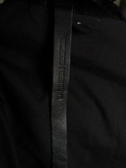 Close-up of a black textured leather belt with 'BURGA' debossed vertically, attached to a black garment.