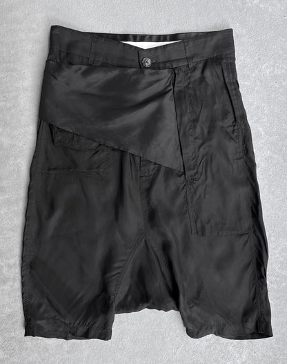 Rick Owens SS14 “VICIOUS” Lightweight Memphis Shorts in black, knee-length, with shiny asymmetrical flap and single button closure. Tagged IT40 (fits US 28-29). Flawless condition. Laid flat on light gray surface.