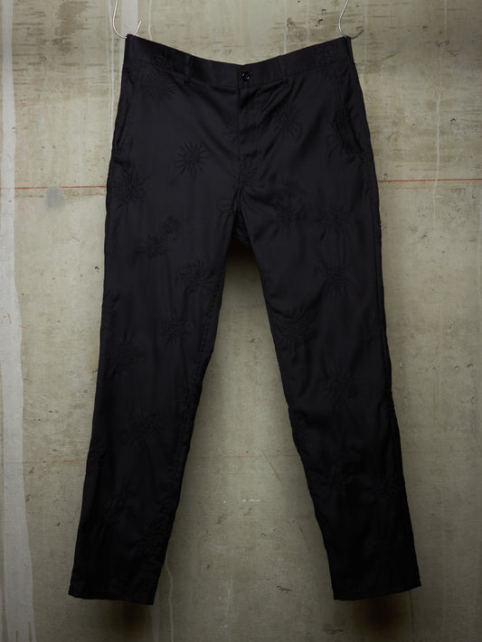 Black pants on a textured beige background
