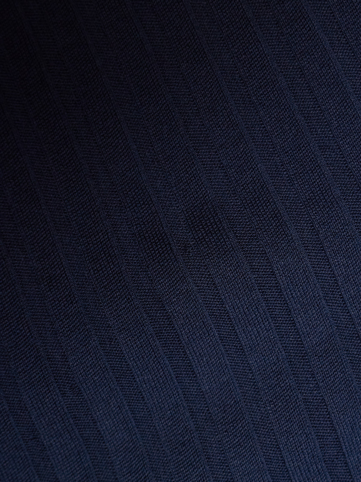 A close-up of dark navy blue textured fabric with a subtle diagonal woven pattern.