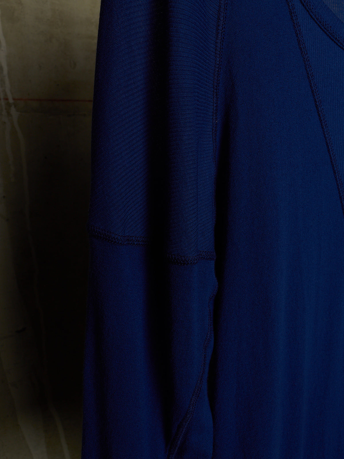 A close-up of a dark blue ribbed athletic top, showing the textured fabric and shoulder seam details.