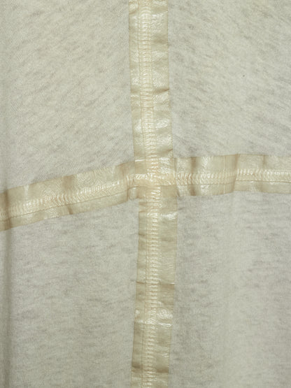 Close-up of a light heather gray fabric with a cream-colored satin cross seam or trim intersecting at the center.