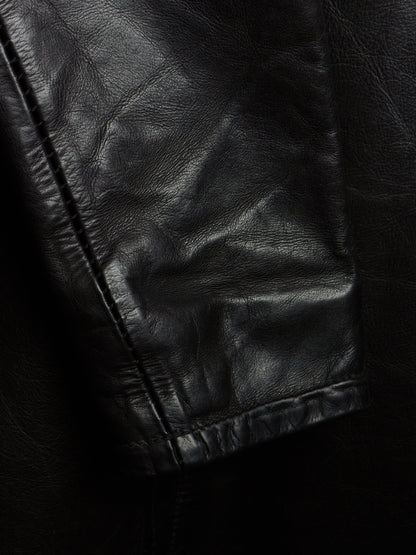 Close-up of a black leather jacket showing the texture and stitching of the sleeve cuff.