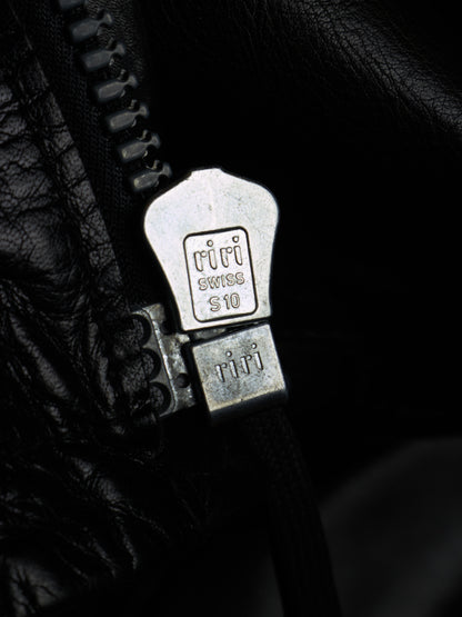 Close-up of a black leather zipper with a silver metal pull tab engraved with 'Tifi' and 'Swiss 10'.