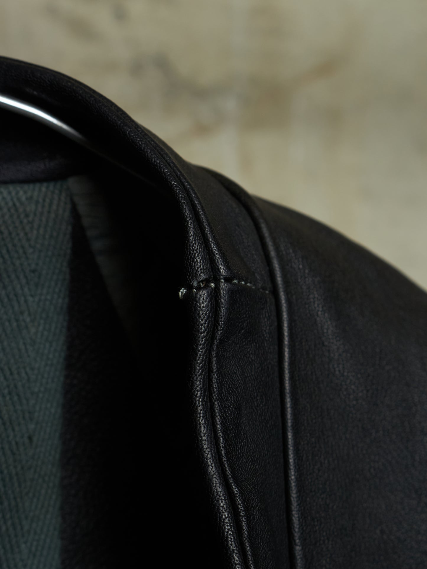 Close-up of a black leather jacket with a blurred background