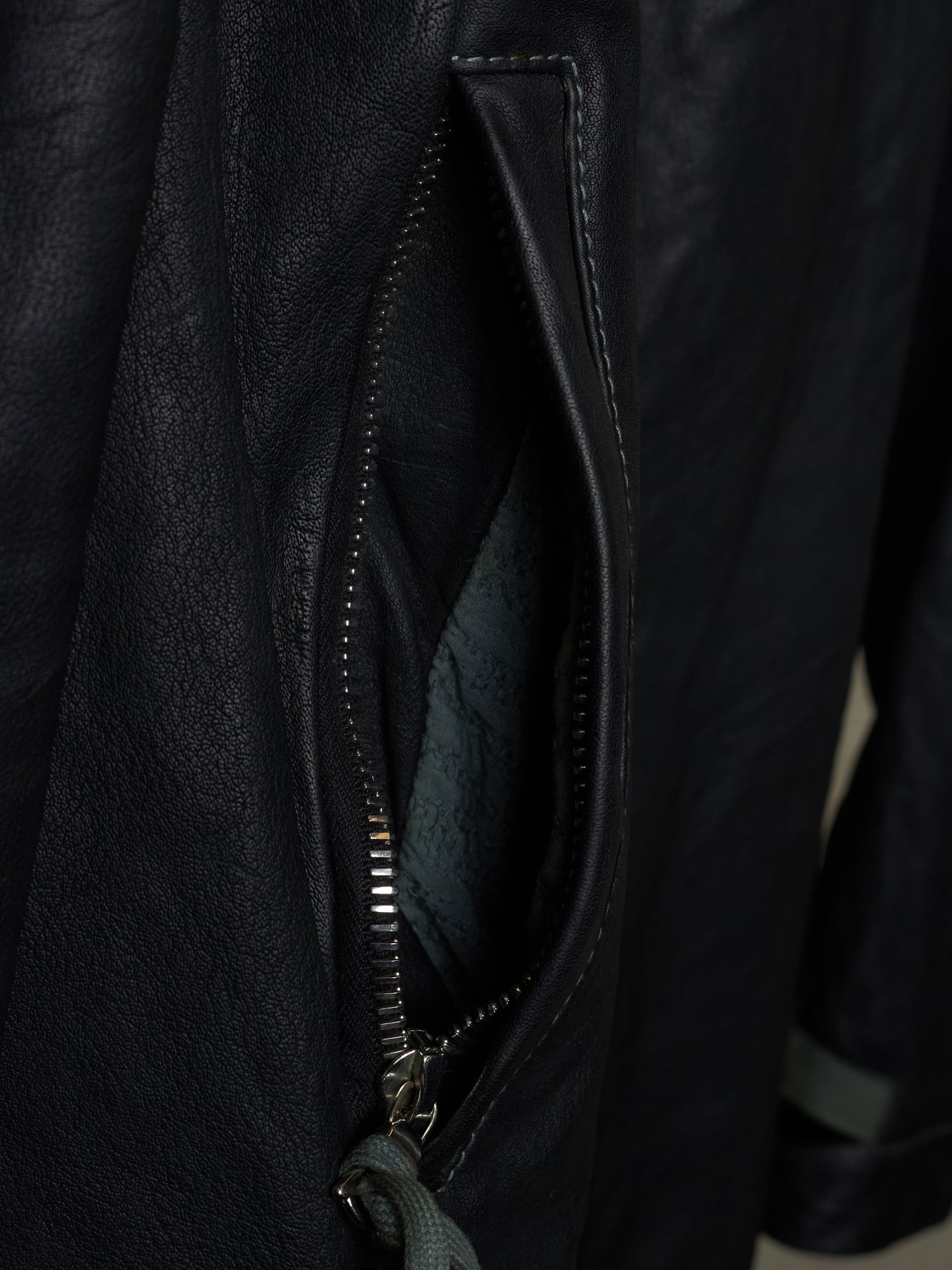 Close-up of a black leather jacket with a zipper