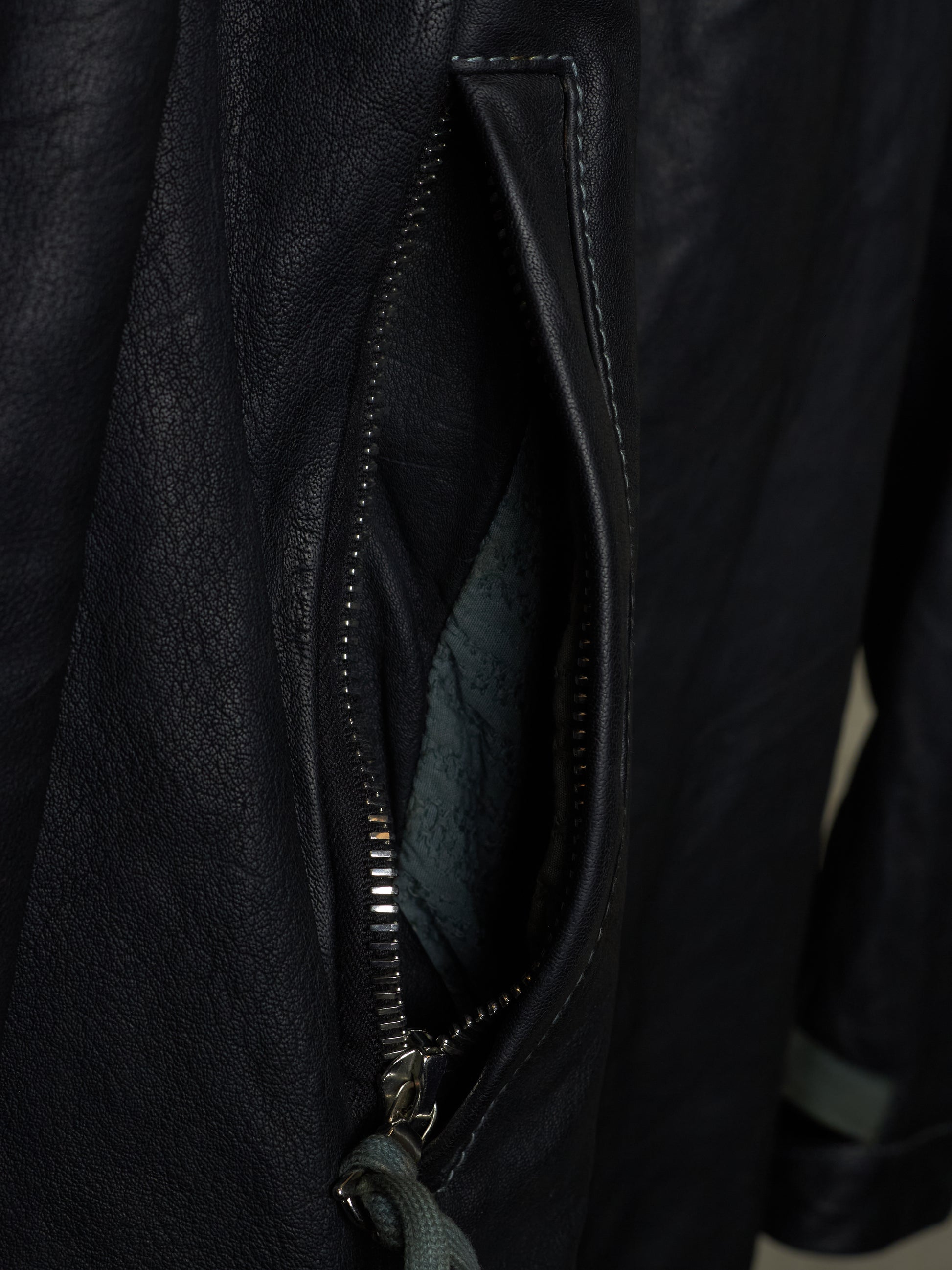 Close-up of a black leather jacket with a zipper