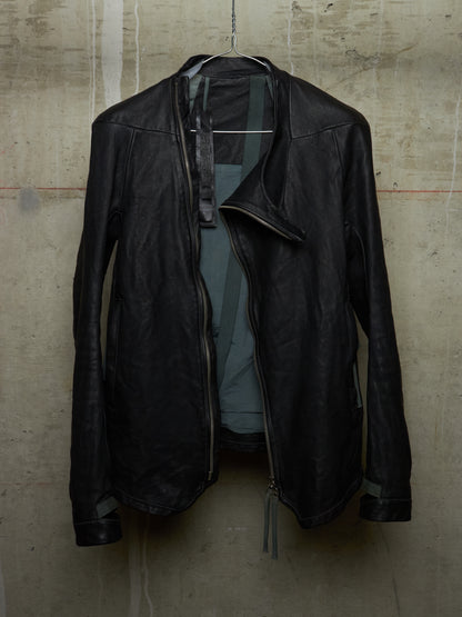 Black leather jacket hanging on a textured wall