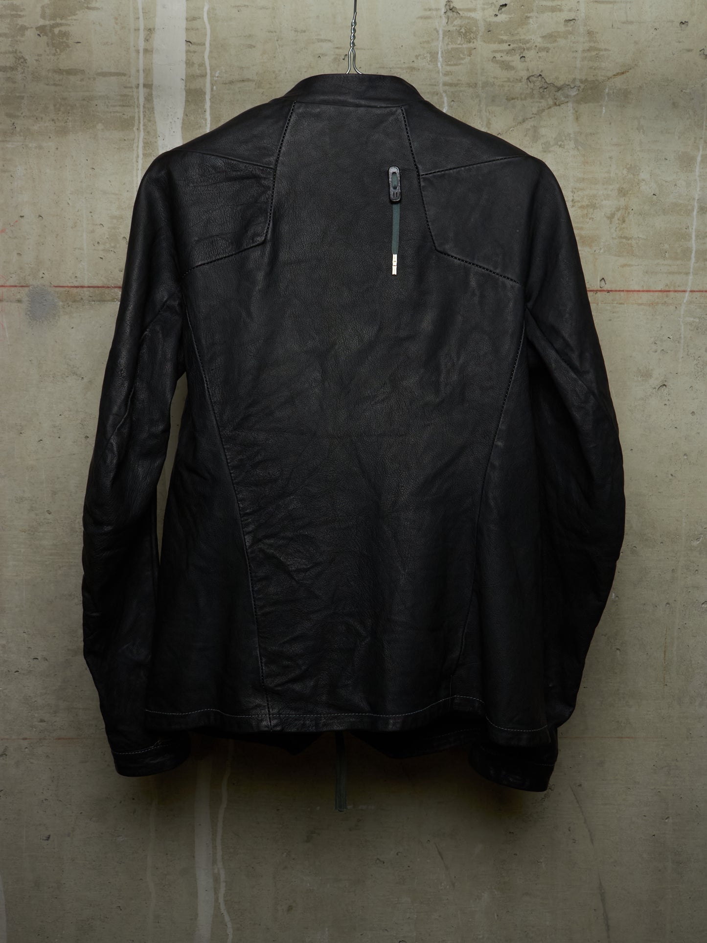 Black jacket on a textured beige wall