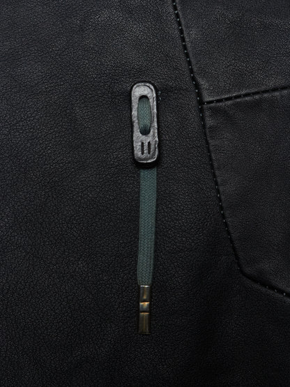 Close-up of a black jacket with a green zipper and button detail.