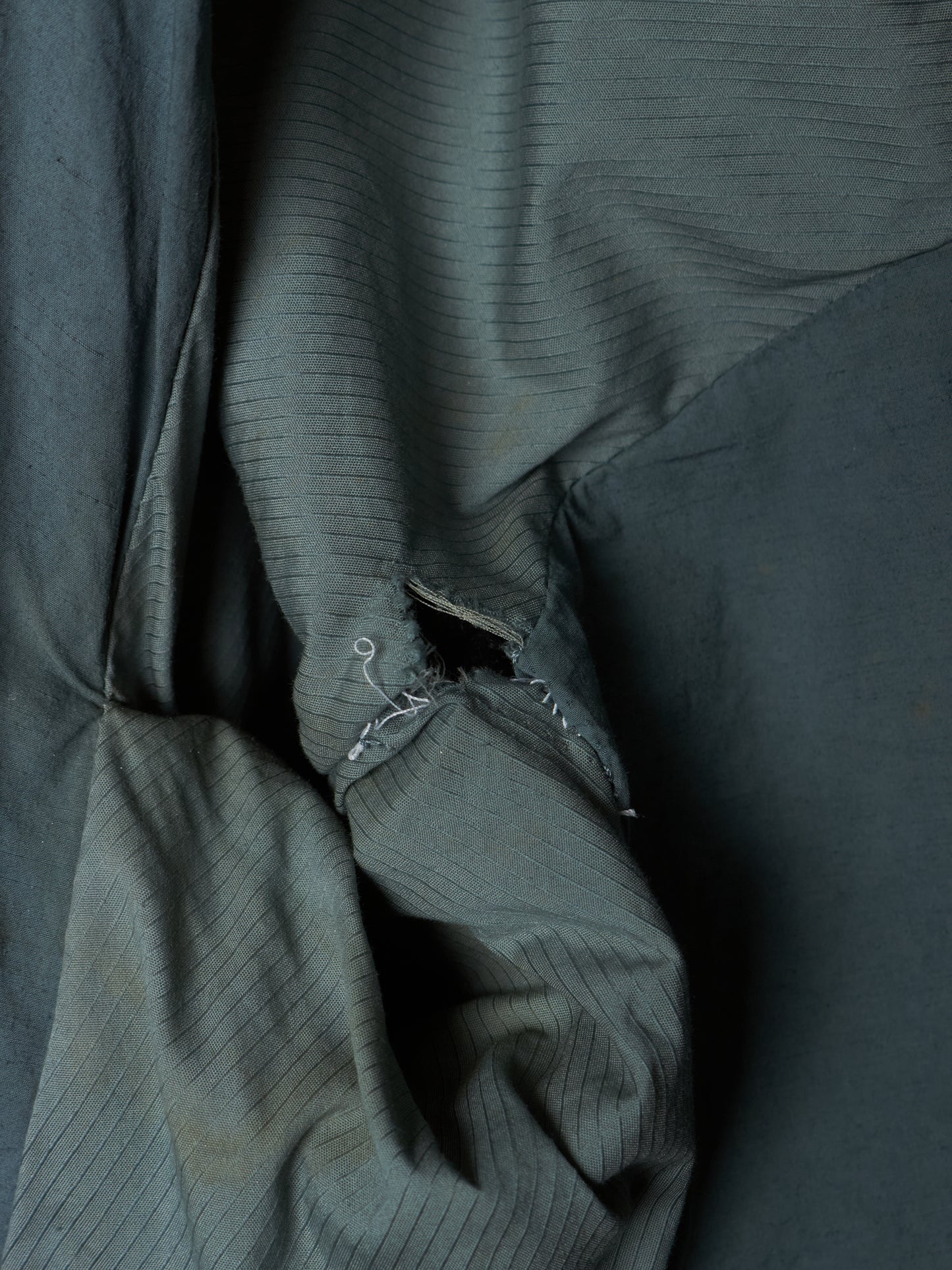 Close-up of a textured dark green fabric with folds