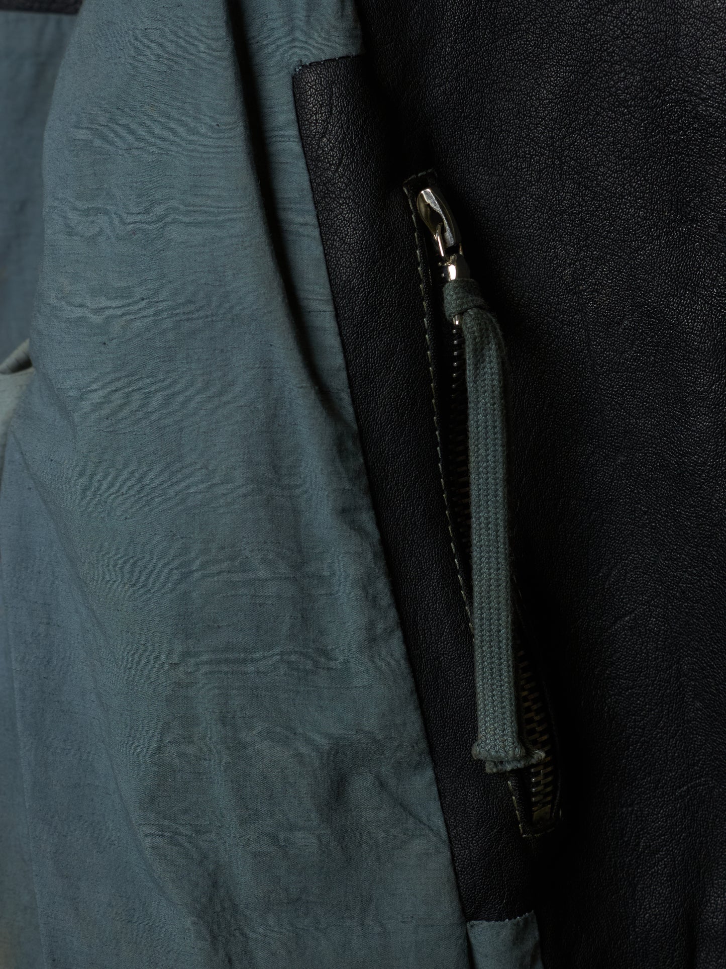 Close-up of a zipper on a dark blue fabric surface