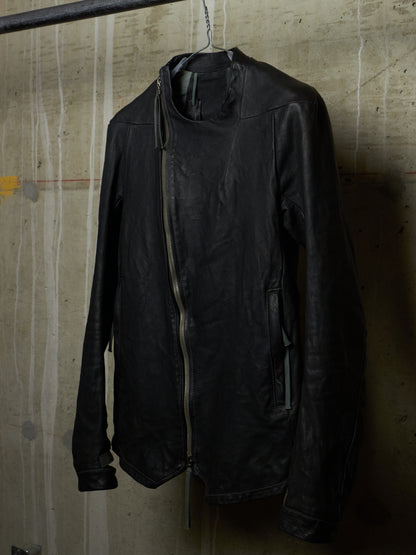 Black jacket hanging on a hanger against a textured wall.