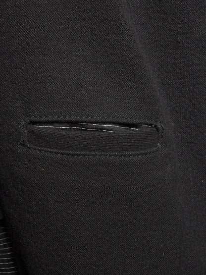 Close-up of a black textured fabric garment showing a horizontal welt pocket and fine knit or woven texture.