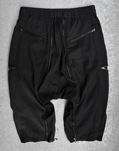 A pair of DRIEW Julius_7 SS10 “neurbanvolker;” Convertible Multi-zip Cotton Twill Shorts, black, size 2 (US 29-32 waist), with multiple silver zippers on pockets and legs, laid flat on a light gray surface in flawless condition.
