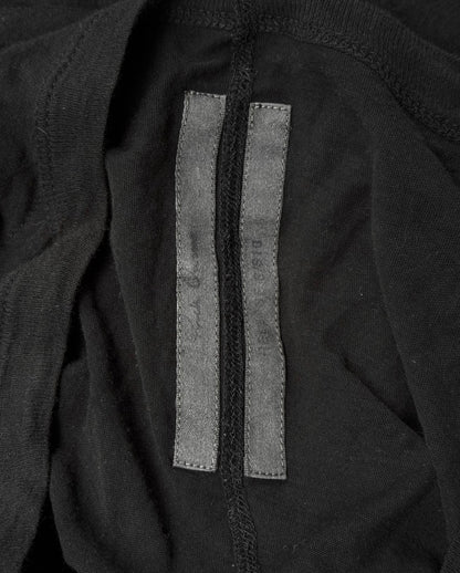A close-up of the interior of a Rick Owens SS10 “RELEASE” Black Sheer Long-sleeves, highlighting a vertical seam and two slim black fabric tags sewn side by side—a signature touch in Rick Owens avant-garde style.