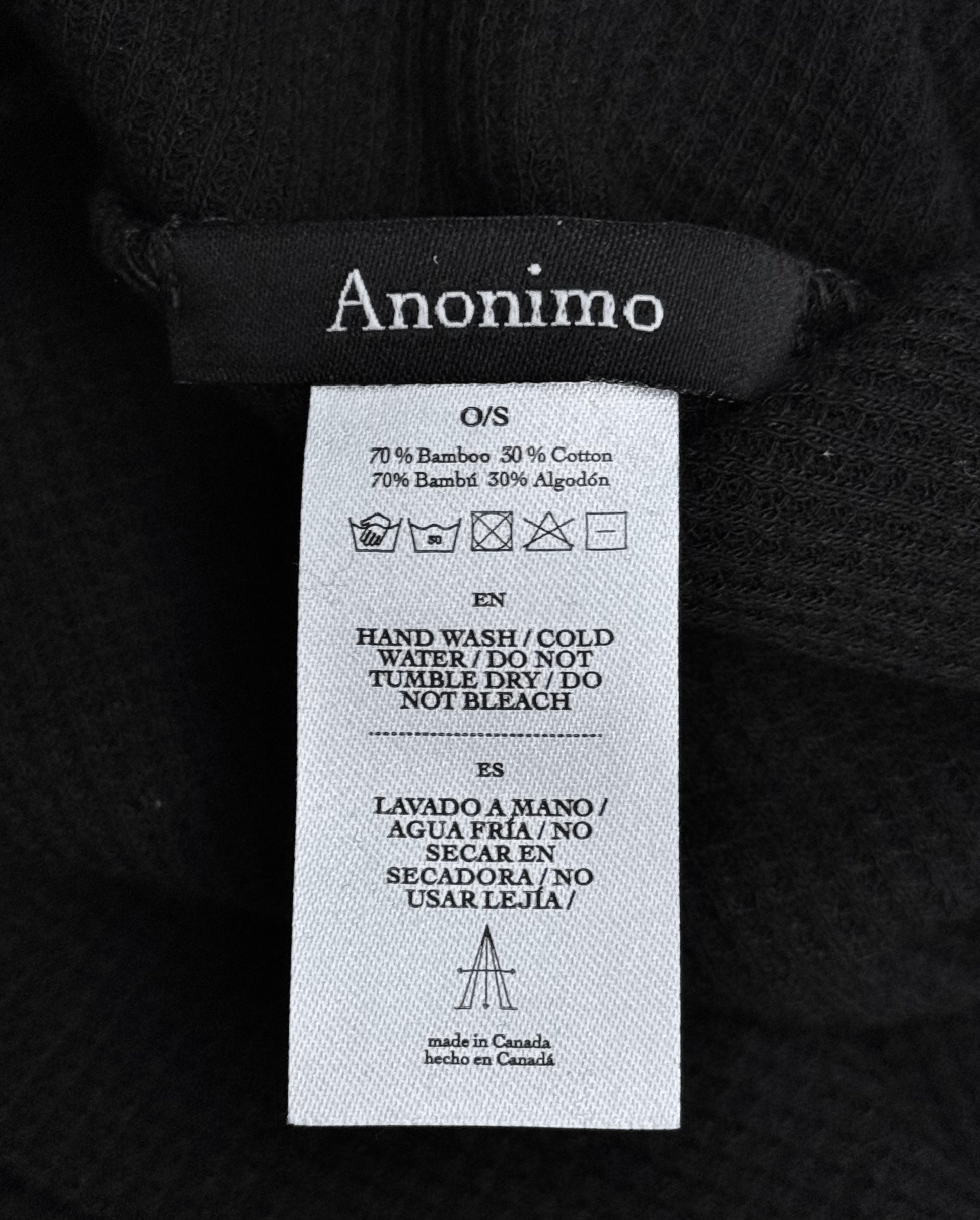 A close-up of a Maison Anonimo label on the Cross-Dart Cotton-bamboo Hat, showing 70% bamboo/30% cotton in English and Spanish, care symbols, washing instructions, and “Made in Canada”—ideal for fans of MAISON ANONIMO.