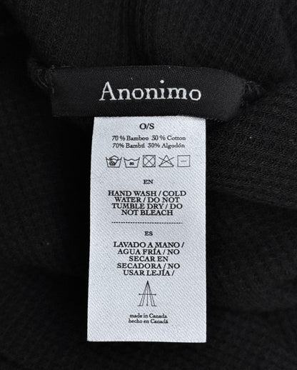 A close-up of a Maison Anonimo label on the Cross-Dart Cotton-bamboo Hat, showing 70% bamboo/30% cotton in English and Spanish, care symbols, washing instructions, and “Made in Canada”—ideal for fans of MAISON ANONIMO.