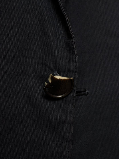 Close-up of a black pinstriped jacket or blazer with a dark brown button.