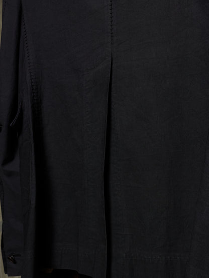 Close-up of a black garment, showing the fabric texture and a vertical seam detail.