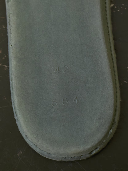 A close-up of a gray suede or nubuck shoe insole, showing the stamped numbers '42' and '554' on the surface.