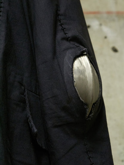 Close-up of a black jacket with a patch on an urban background