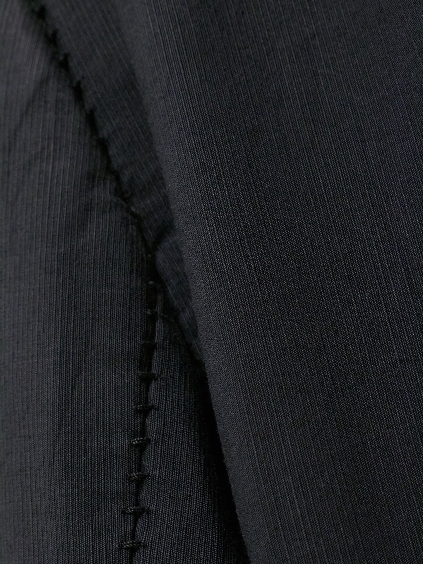 Close-up of a black fabric with a visible seam