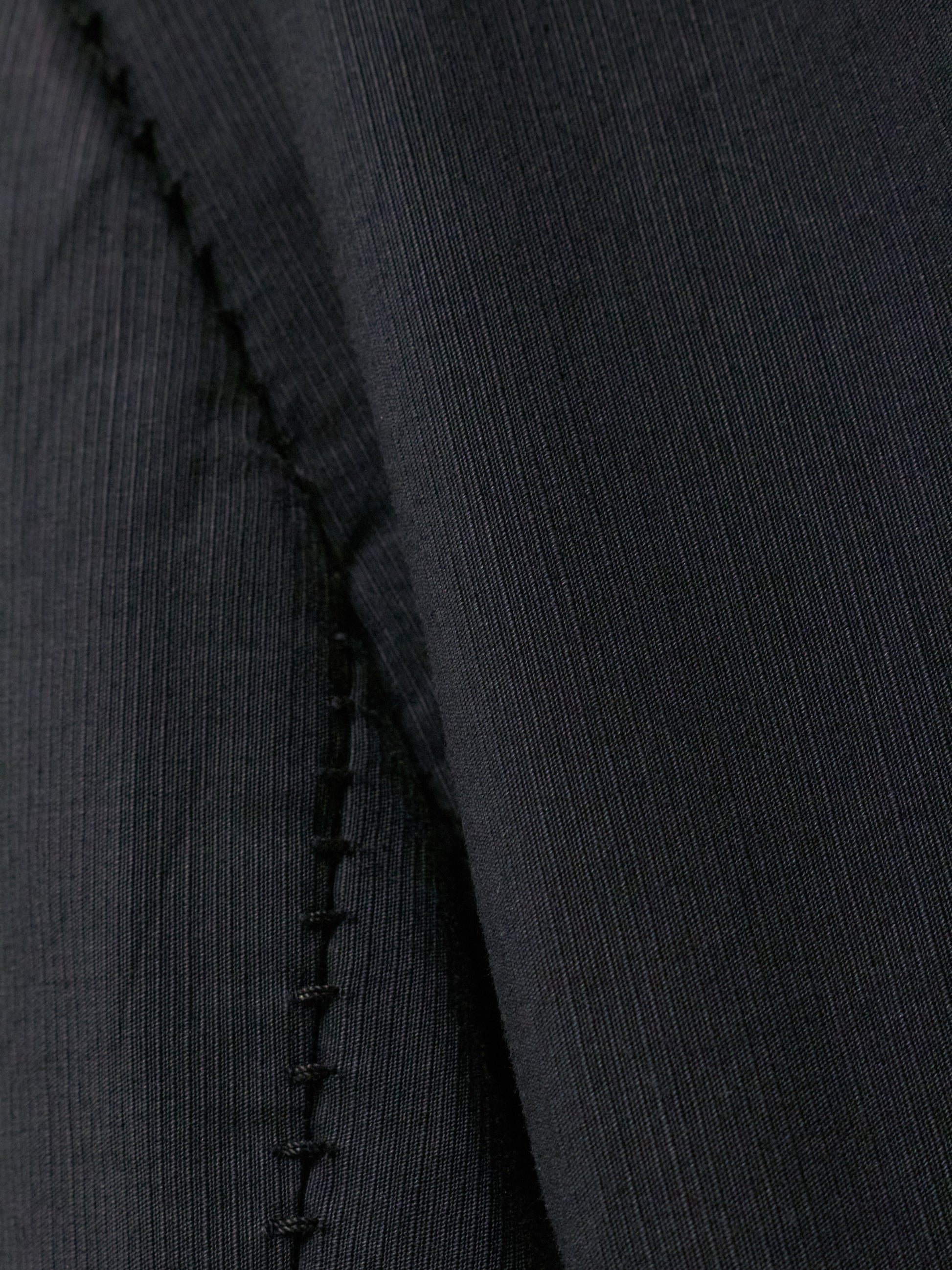 Close-up of a black fabric with a visible seam