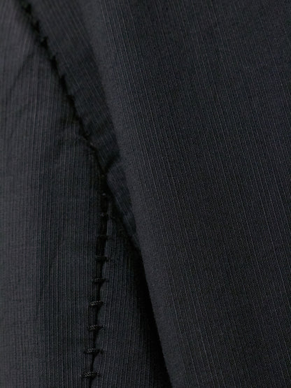 Close-up of a black fabric with a visible seam