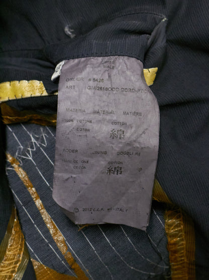 Close-up of a clothing label on a garment with gold and black details.