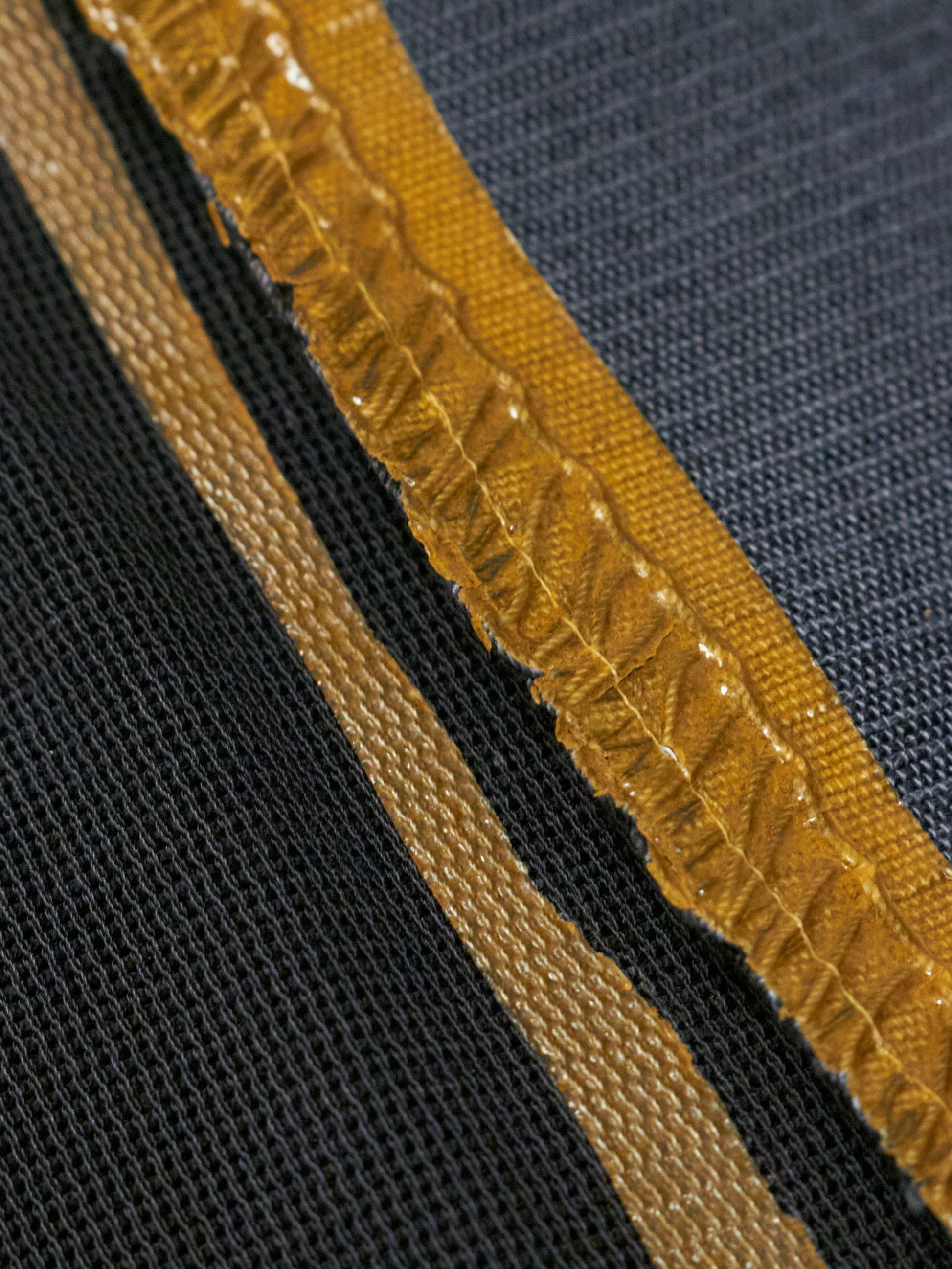 Close-up of a textured fabric with a yellow border on a black background