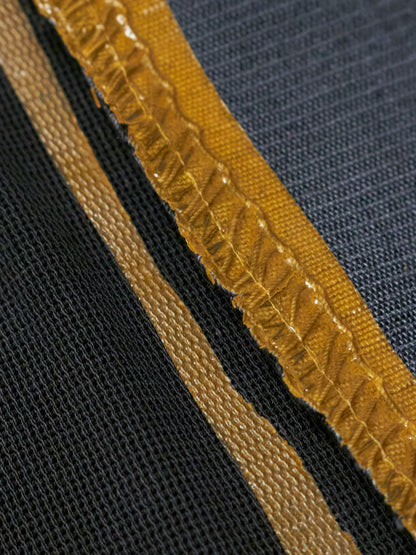 Close-up of a textured fabric with a yellow border on a black background