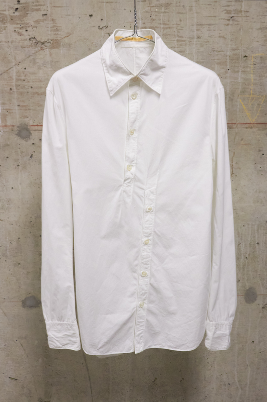 White shirt on a hanger against a textured wall