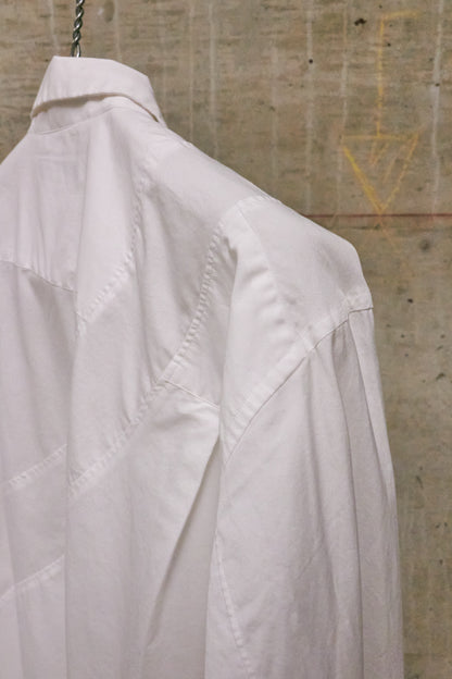 White shirt hanging against a textured wall.