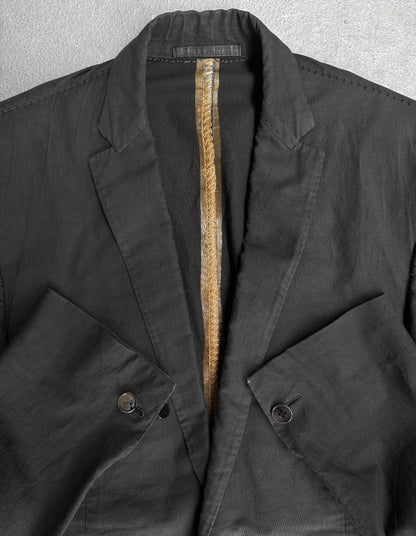 Close-up of a dark jacket with a zipper and button details on a gray background