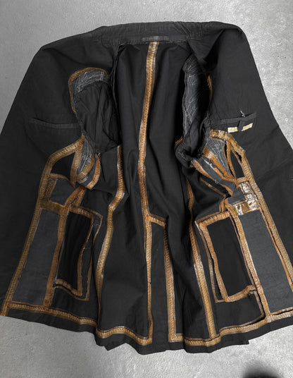 Black garment with gold embroidery on a gray background