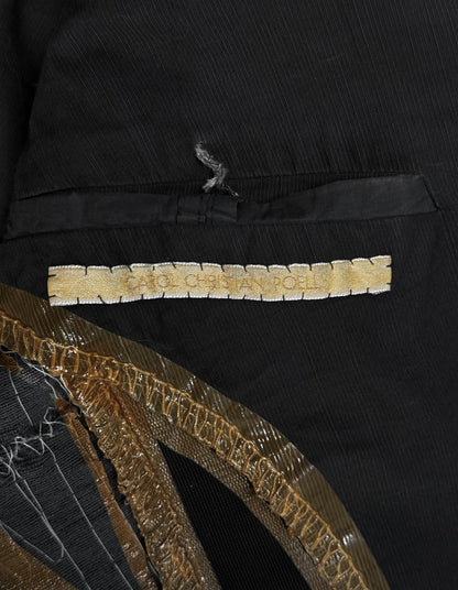 Close-up of a black garment with gold embroidery and text.
