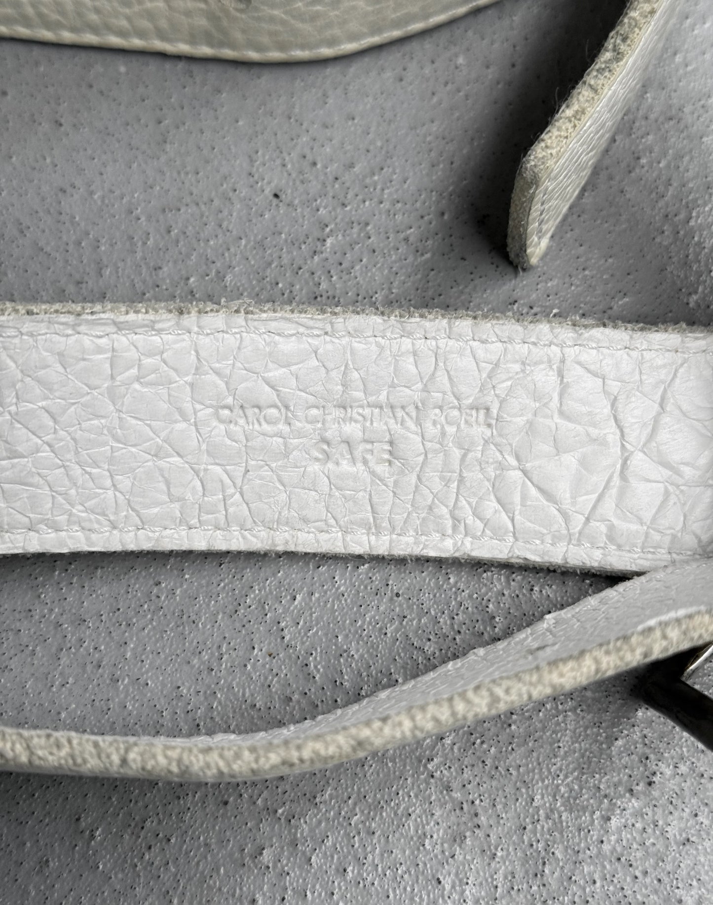 Close-up of a textured white strap on a gray background
